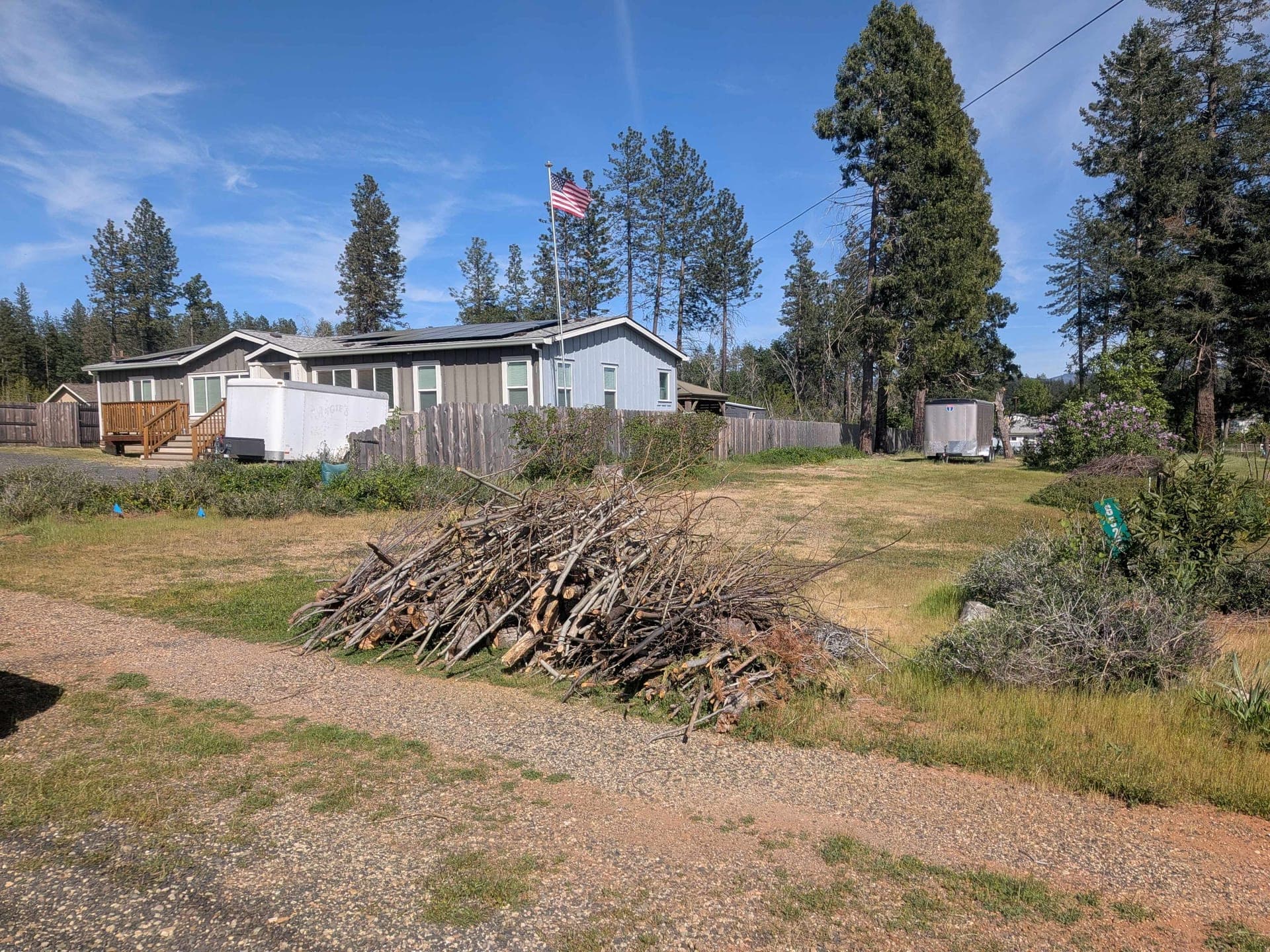Brush and limb piles prepared along a driveway for chipping