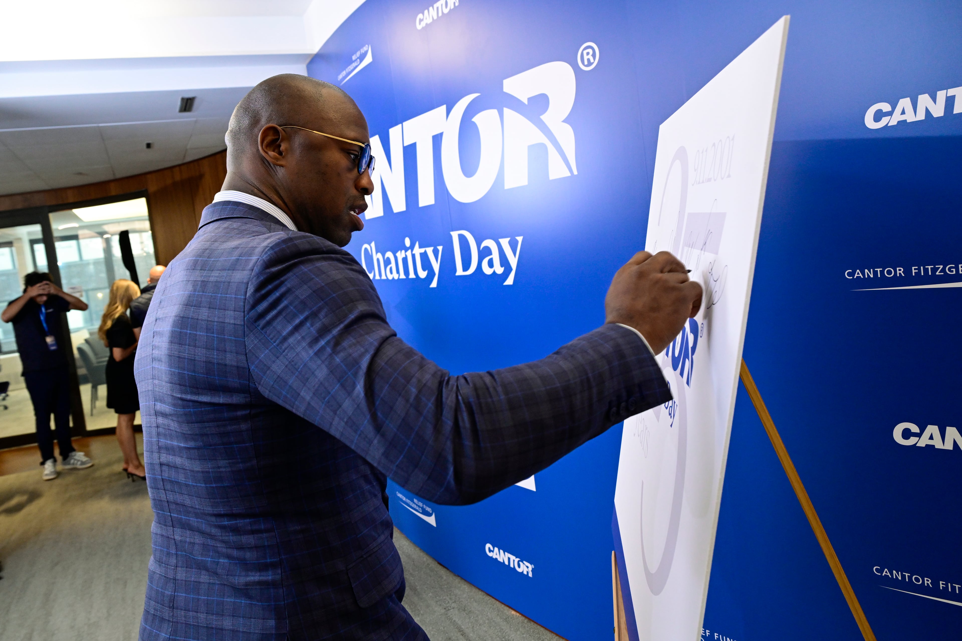 Vernon Davis signs the Cantor Fitzgerald Charity Day poster