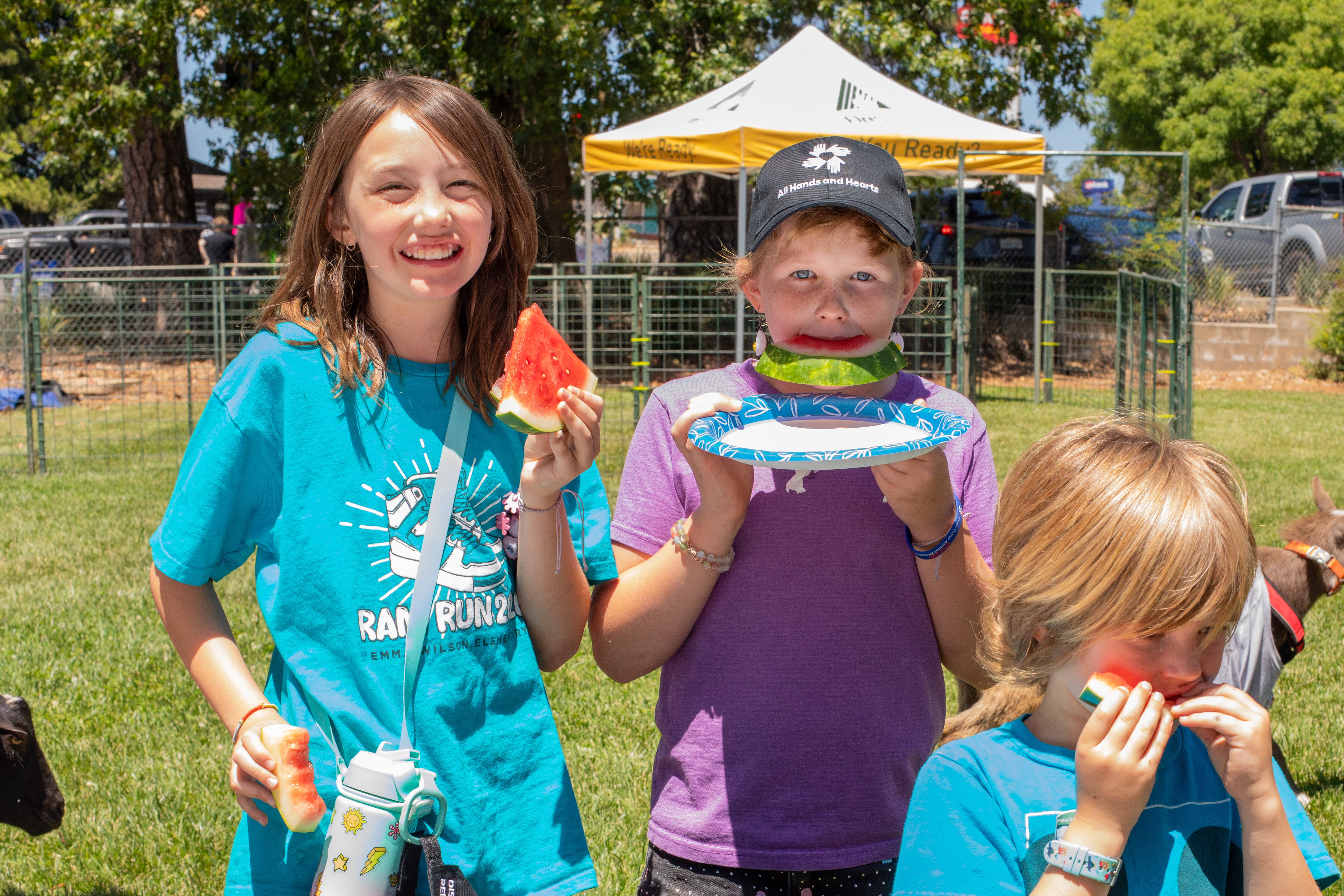 Volunteers high-five at the Paradise Grazing Festival vendor booth
